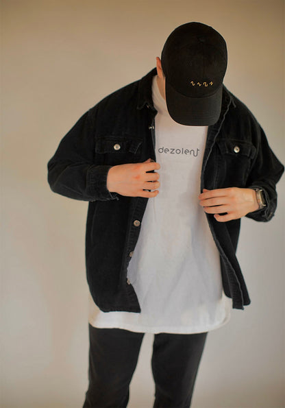 Model Wearing the Dezolent Signature White Garment Dyed Heavyweight Comfort Colors Tee and Basic Shapes Black Dad Hat