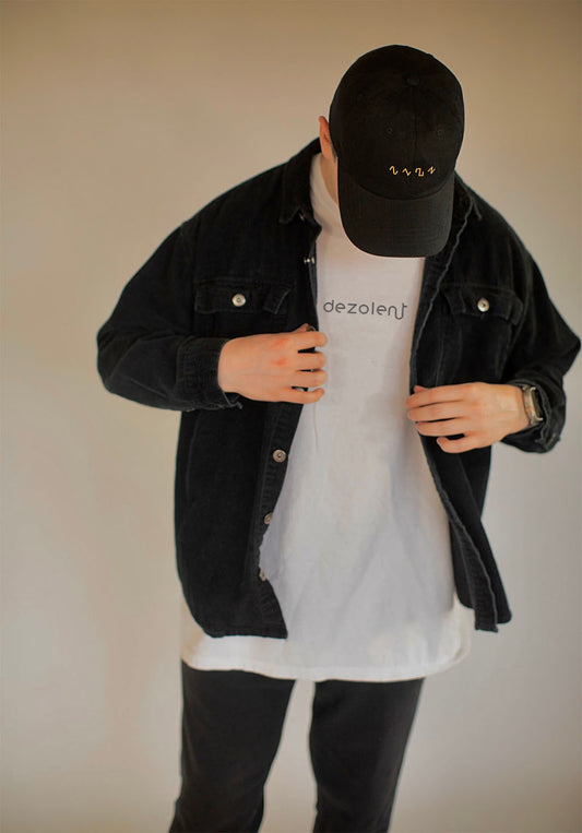 Model Wearing the Dezolent Signature White Garment Dyed Heavyweight Comfort Colors Tee and Basic Shapes Black Dad Hat